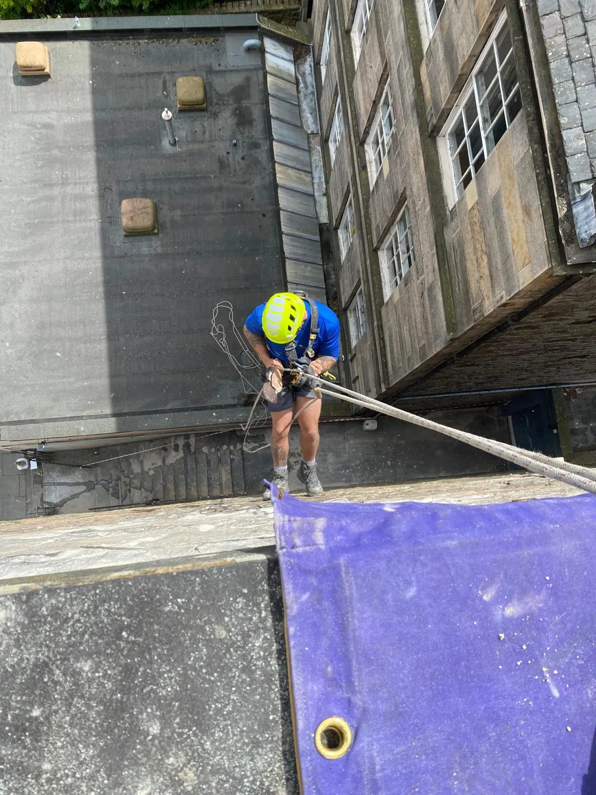 Operative clearing a flat roof between tenement buildings