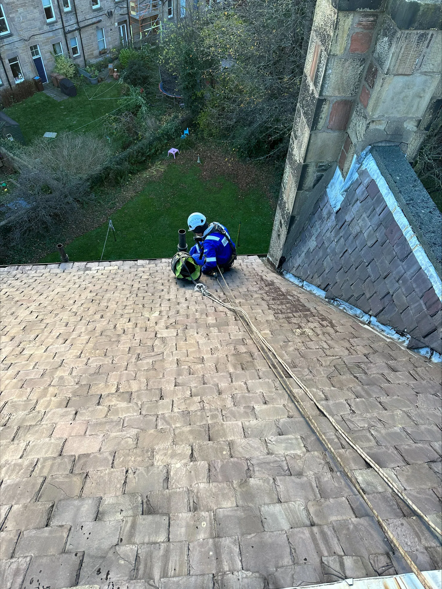 Rope access technician replacing slates