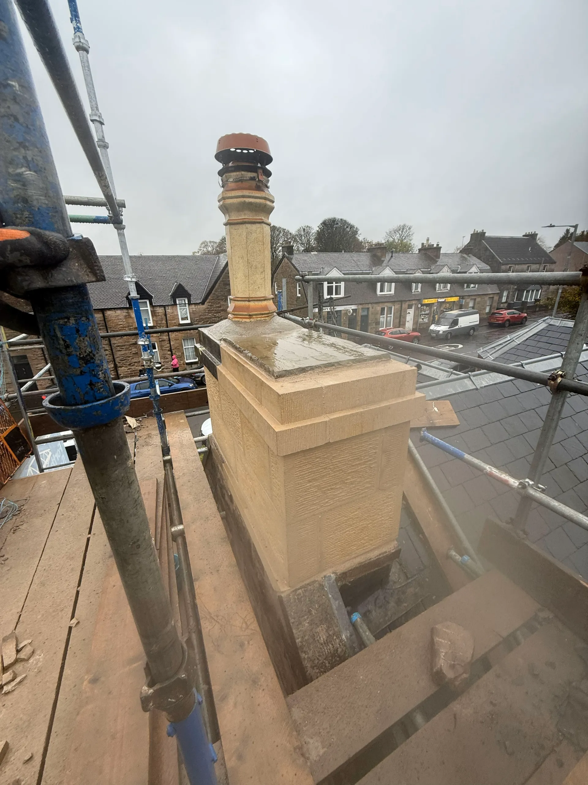 Newly rebuilt ashlar chimney stack with a single clay pot