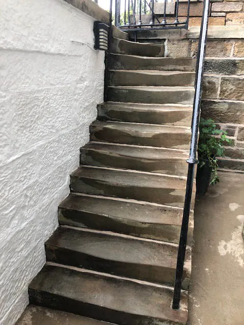 Worn stone entrance steps and iron railings before repair