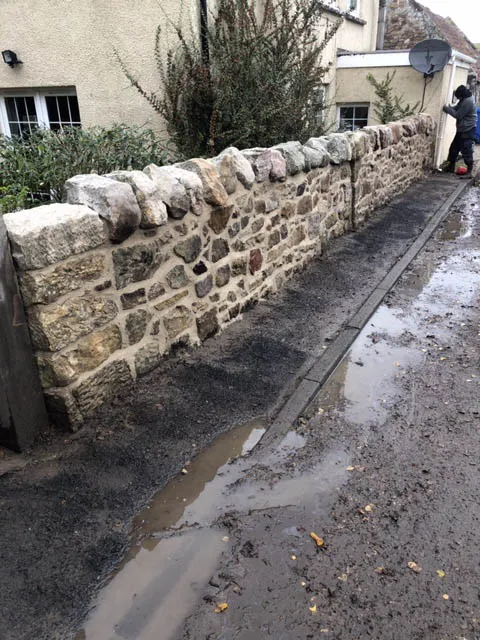 Rubble stone boundary wall along a lane after lime repointing