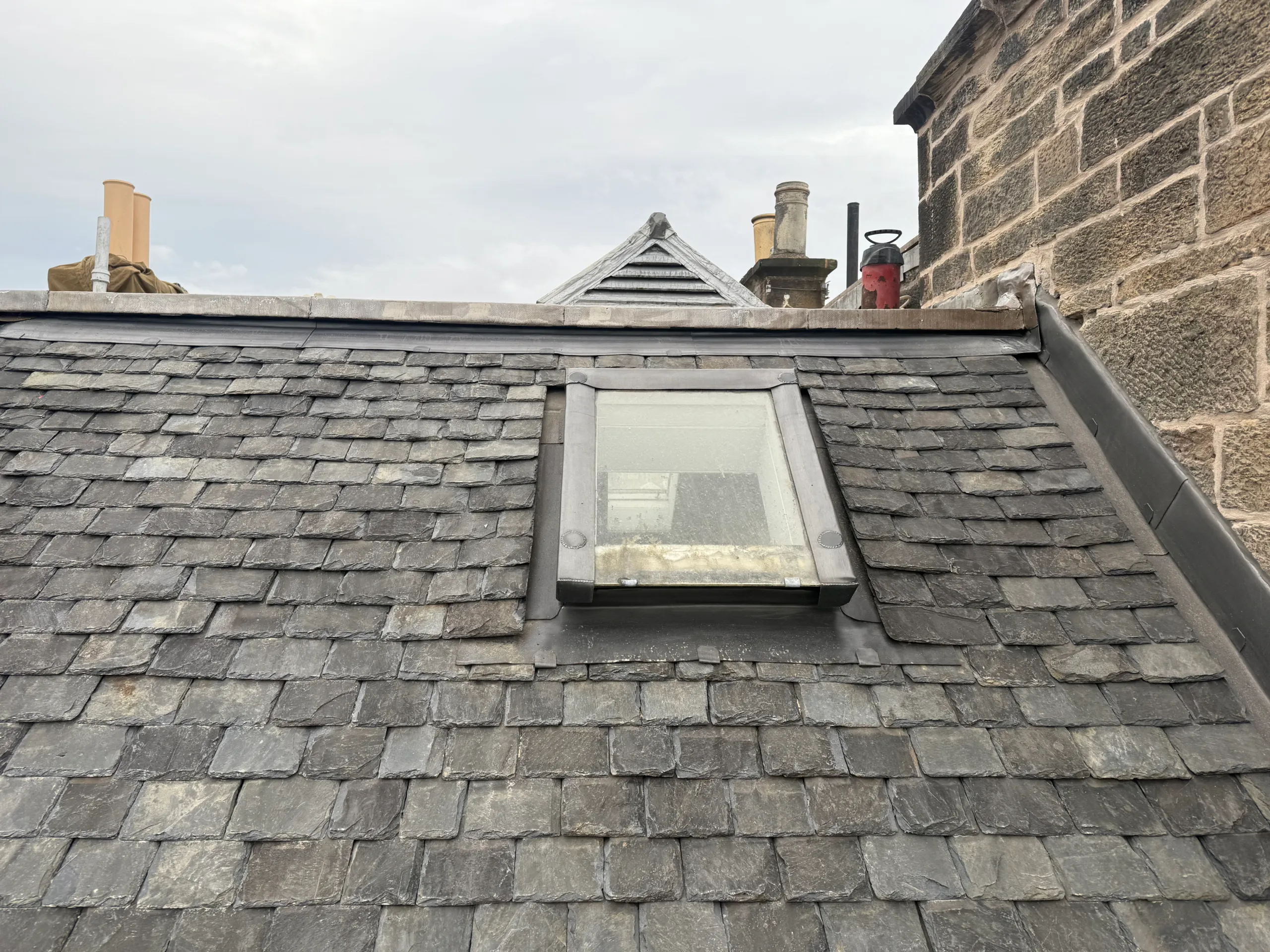 Slate roof with a repaired rooflight and lead flashing