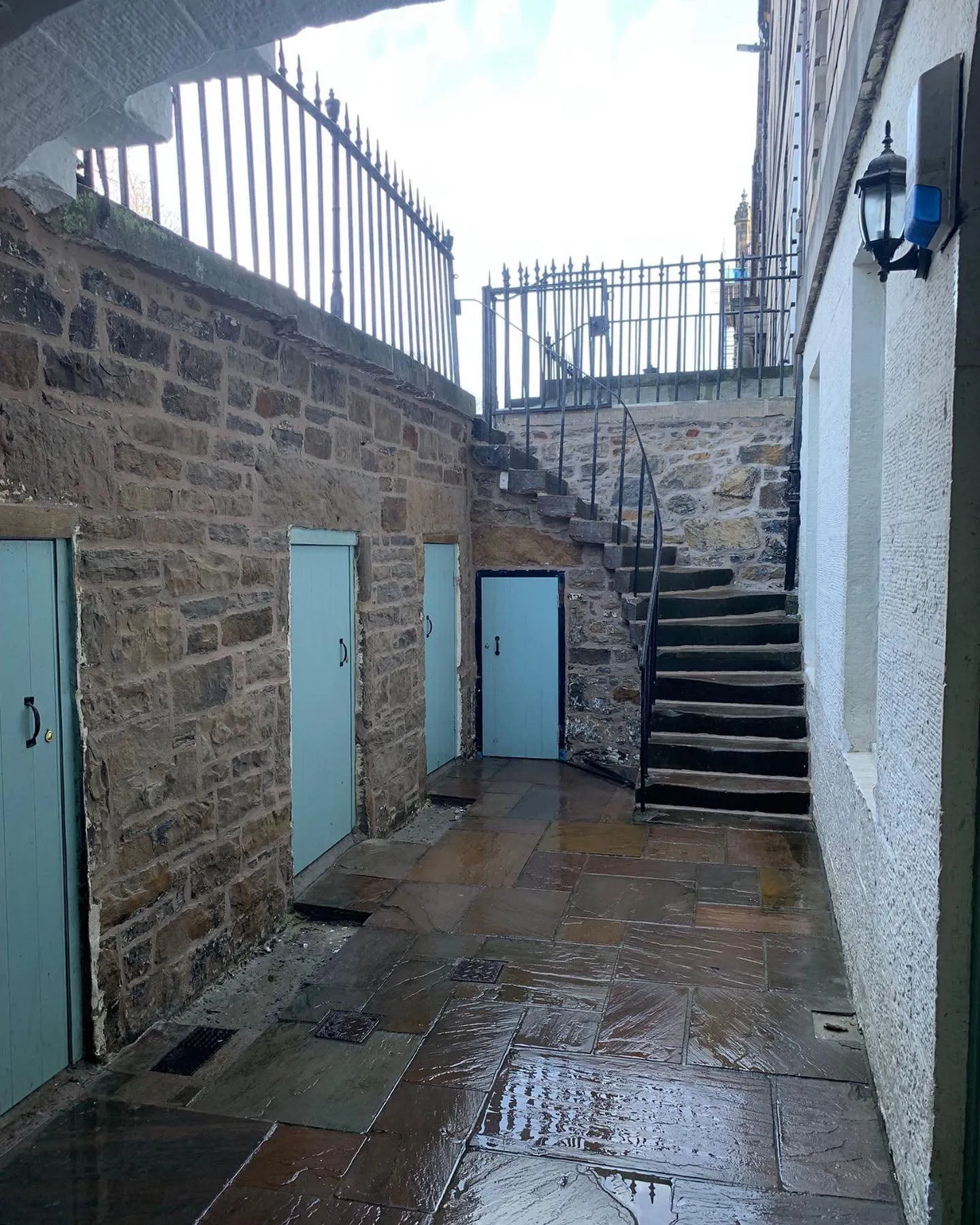 Narrow Edinburgh close with stone walls, stone steps and iron railings