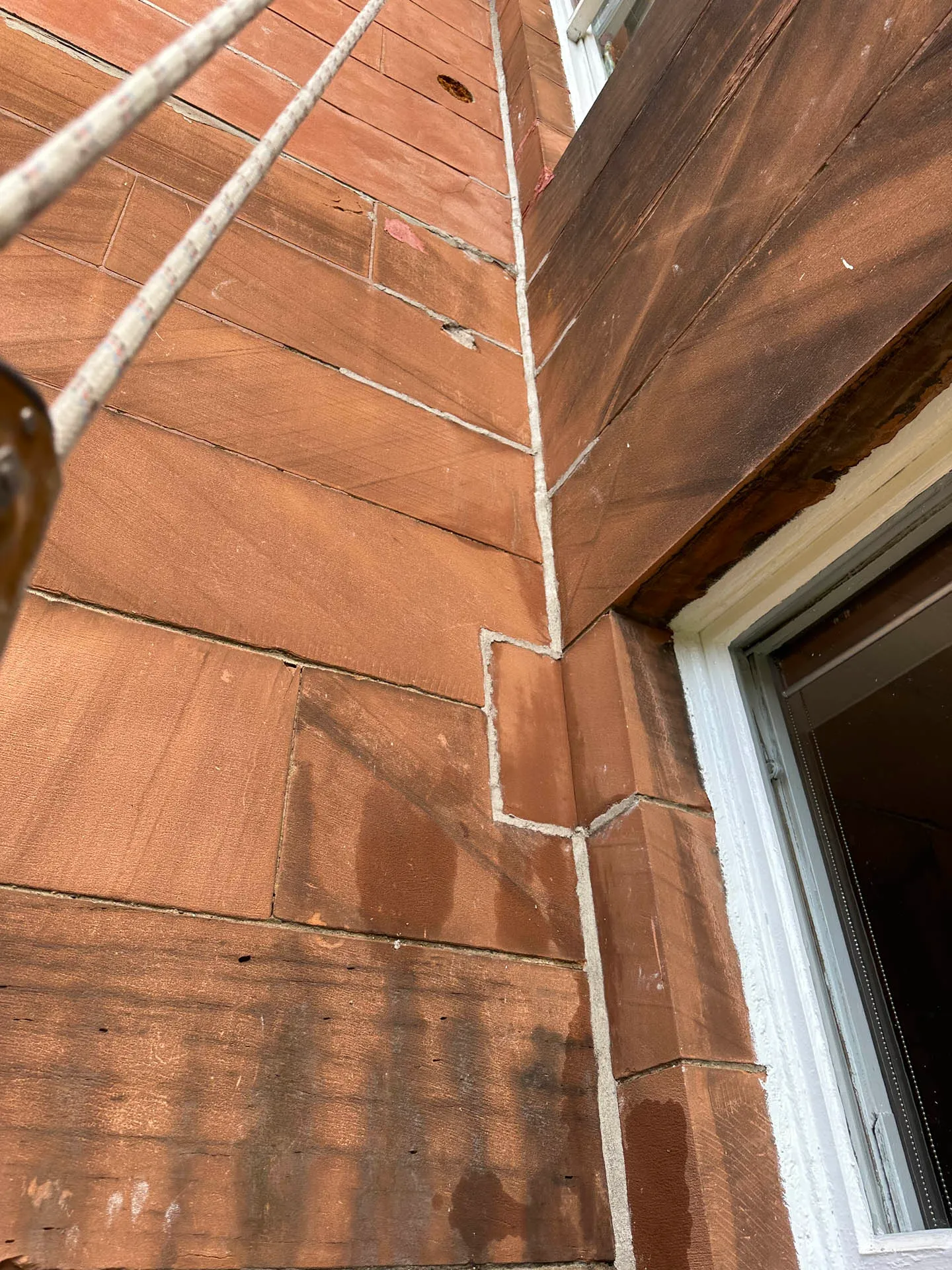 Red sandstone ashlar wall with a newly finished mastic joint