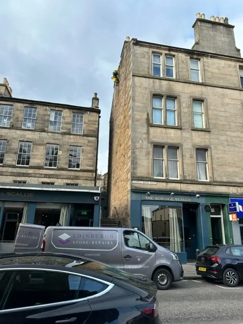 Sandstone tenement building with shops at street level on an Edinburgh street
