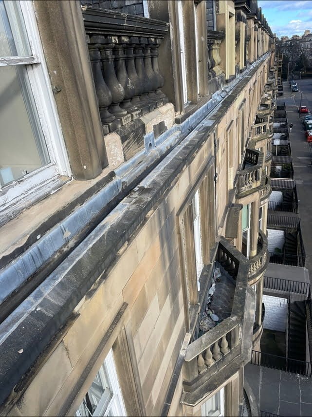 View along a tenement gutter at roof level, looking down the street