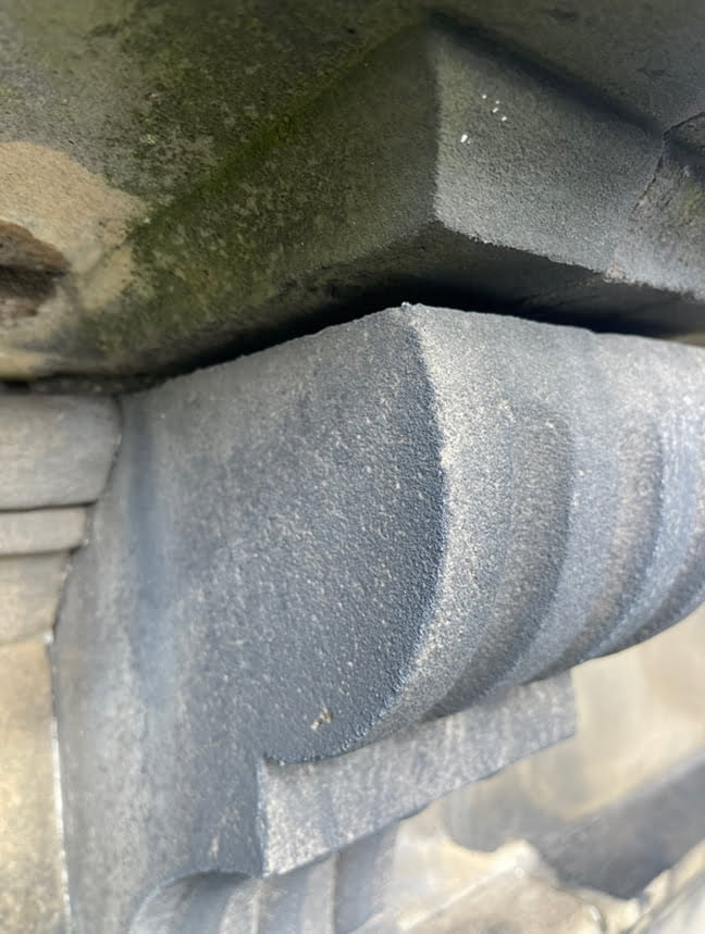 Weathered stone cornice showing erosion and open joints